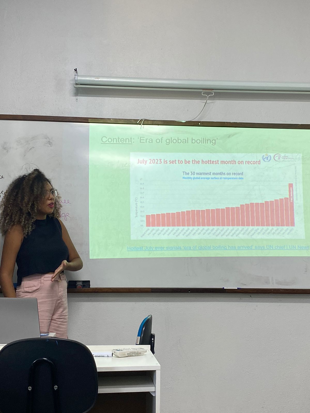 Participante apresentando um gráfico científico em inglês para a turma
